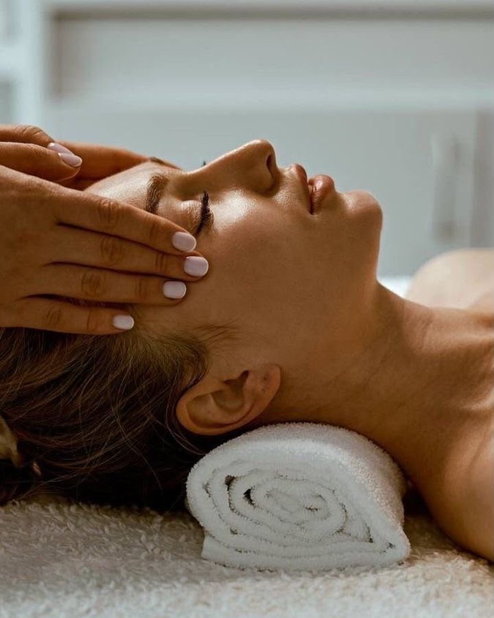 Lymphatic facial massage, the client resting on a rolled towel